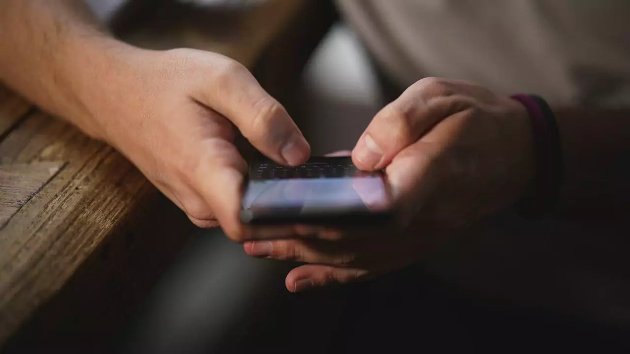 Hands typing on a smartphone